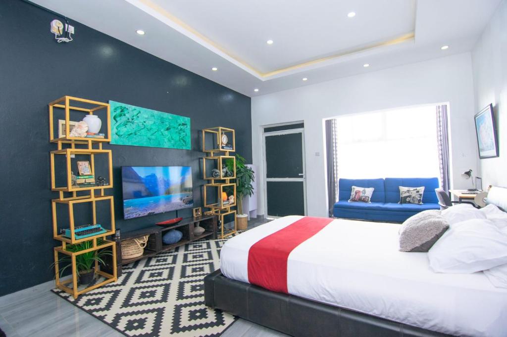 蒙巴萨Beau Fahy Nyali studio apartment的一间卧室配有一张大床和电视
