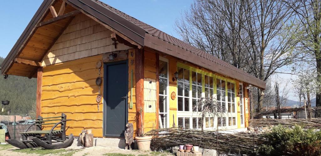 坎普朗莫道尼斯Mica fermă veselă的小木屋设有黄色的门和窗户