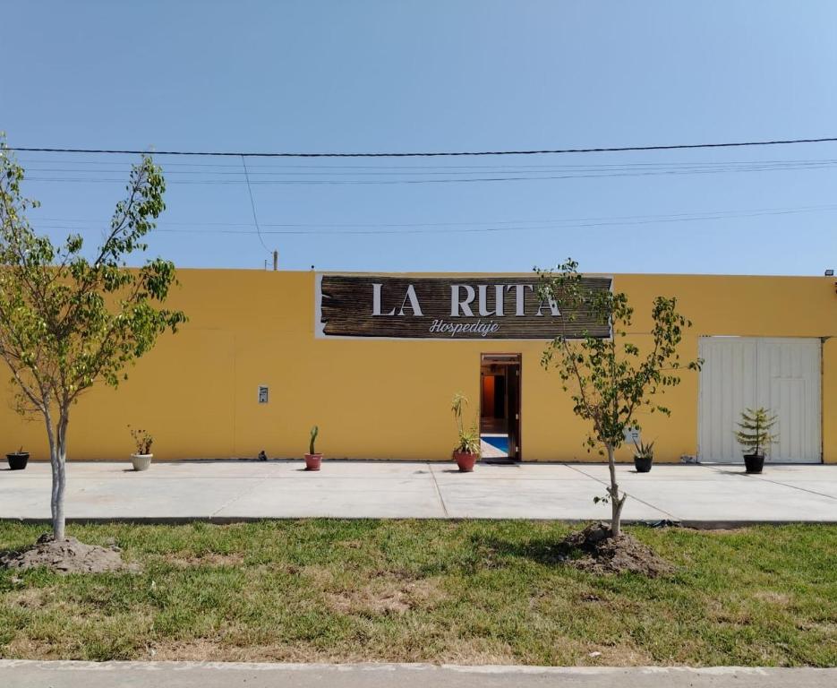 帕拉卡斯La Ruta的黄色的建筑,上面有读拉条的标志