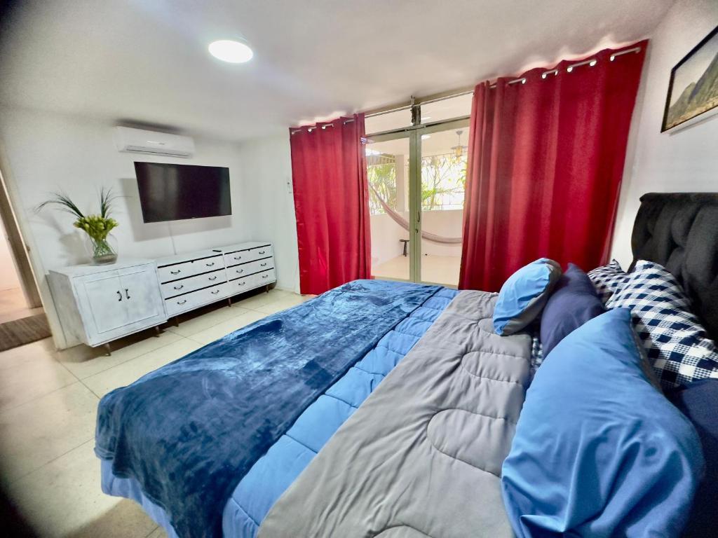 加拉加斯Amplio apartamento renovado con 3 habitaciones, 3 baños, terrazas, Smart TV y wifi incluidos的一间卧室配有一张带红色窗帘的大床