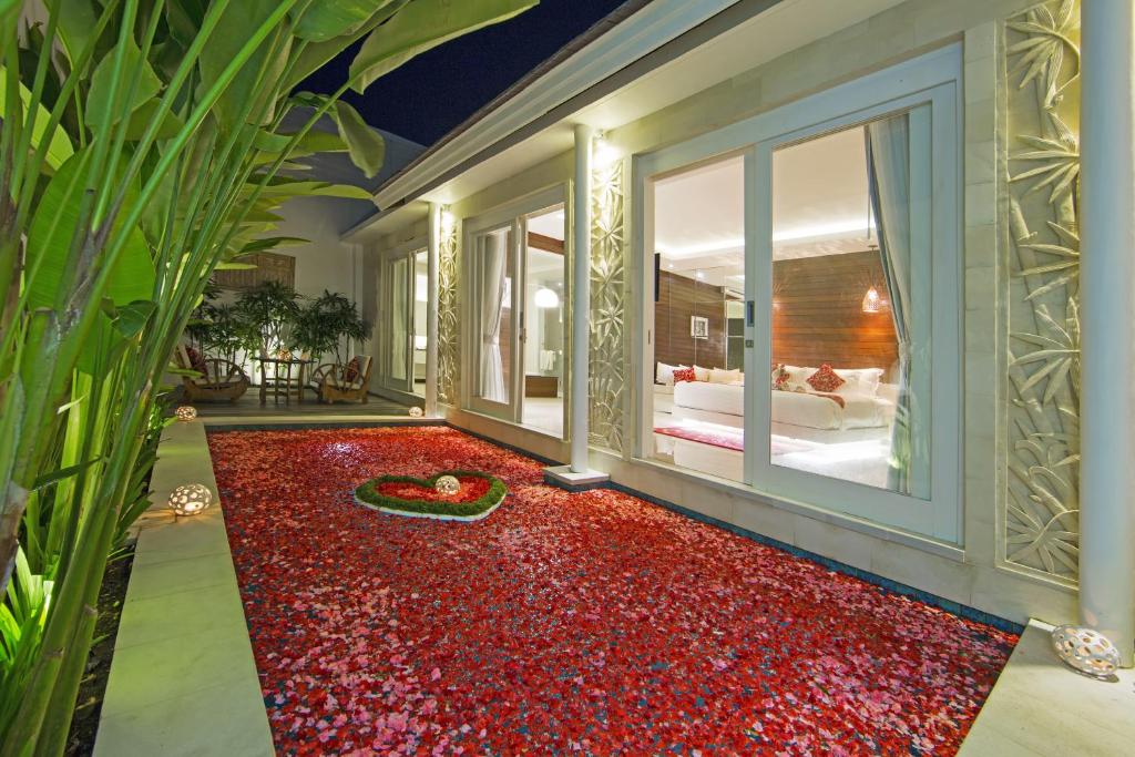 塞米亚克Bajra Bali Villa Seminyak的一间铺有红地毯的客房,位于床前