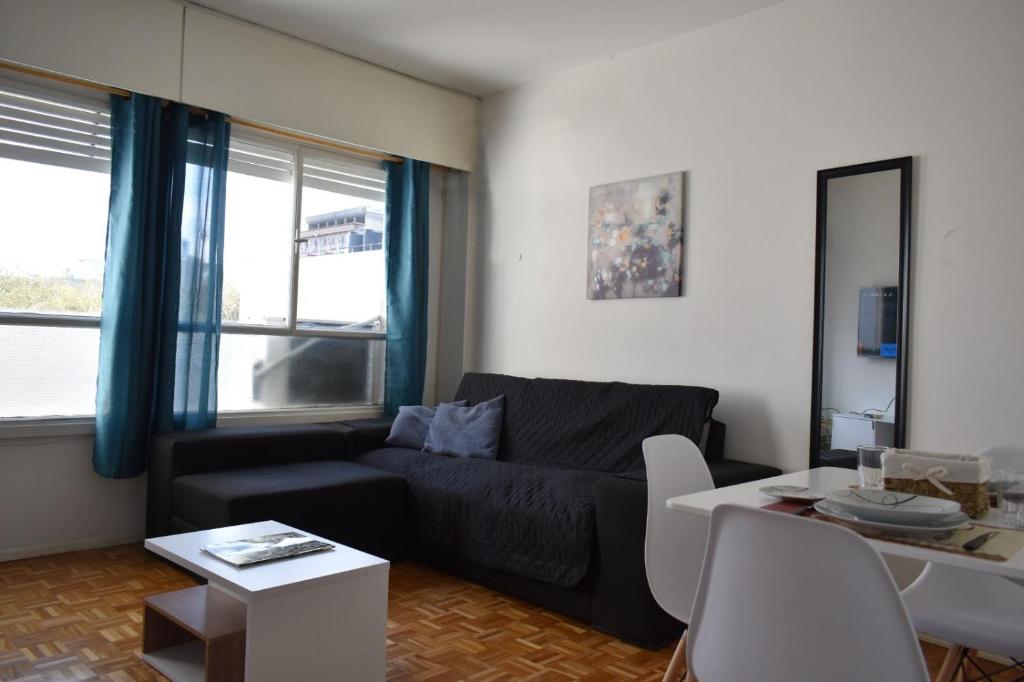 蒙得维的亚Hermoso apartamento en puerta de la Ciudad Vieja的客厅配有黑色沙发和桌子