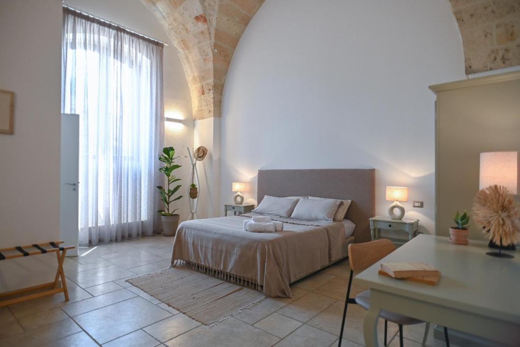 纳尔多地中海公寓式酒店的一间卧室配有一张床和一张桌子