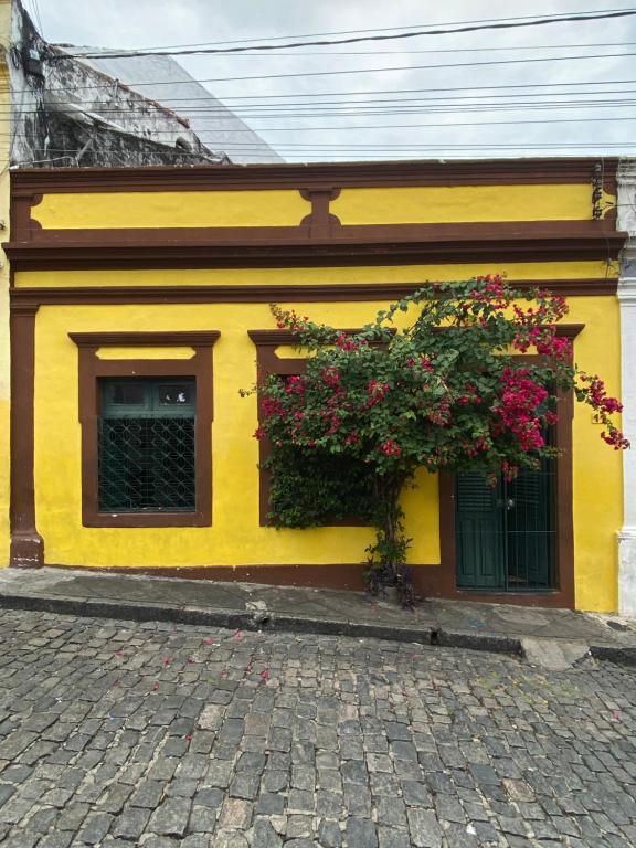 奥林达Casa de Olinda的黄色的建筑,花朵在建筑的一侧