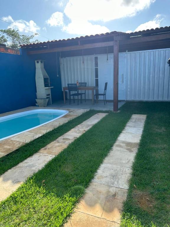 日若卡-迪热里科阿科阿拉Tiny Lagoa的后院设有游泳池、桌子和庭院