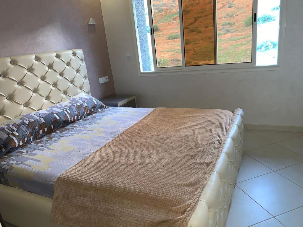 胡塞马Apartments Palace Rif Al Hoceima的一间卧室配有一张大床和大床头板