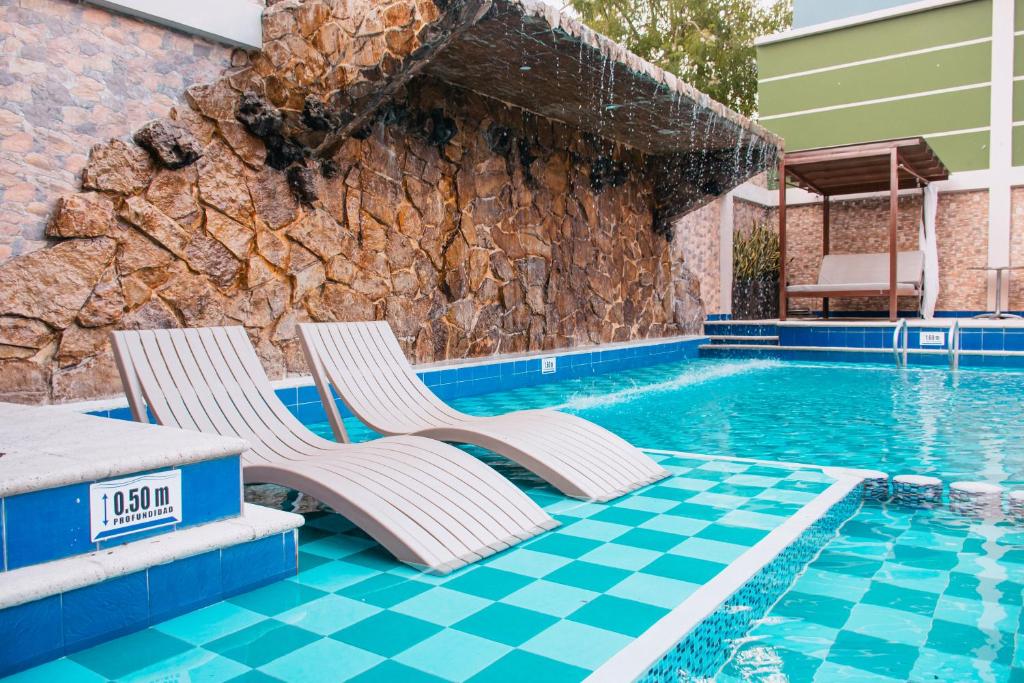 阿劳卡Hotel Punta Arena Spa Boutique的游泳池畔的2把躺椅