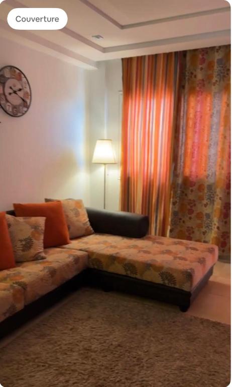 斯法克斯Dar Mim的客厅配有沙发和墙上的时钟