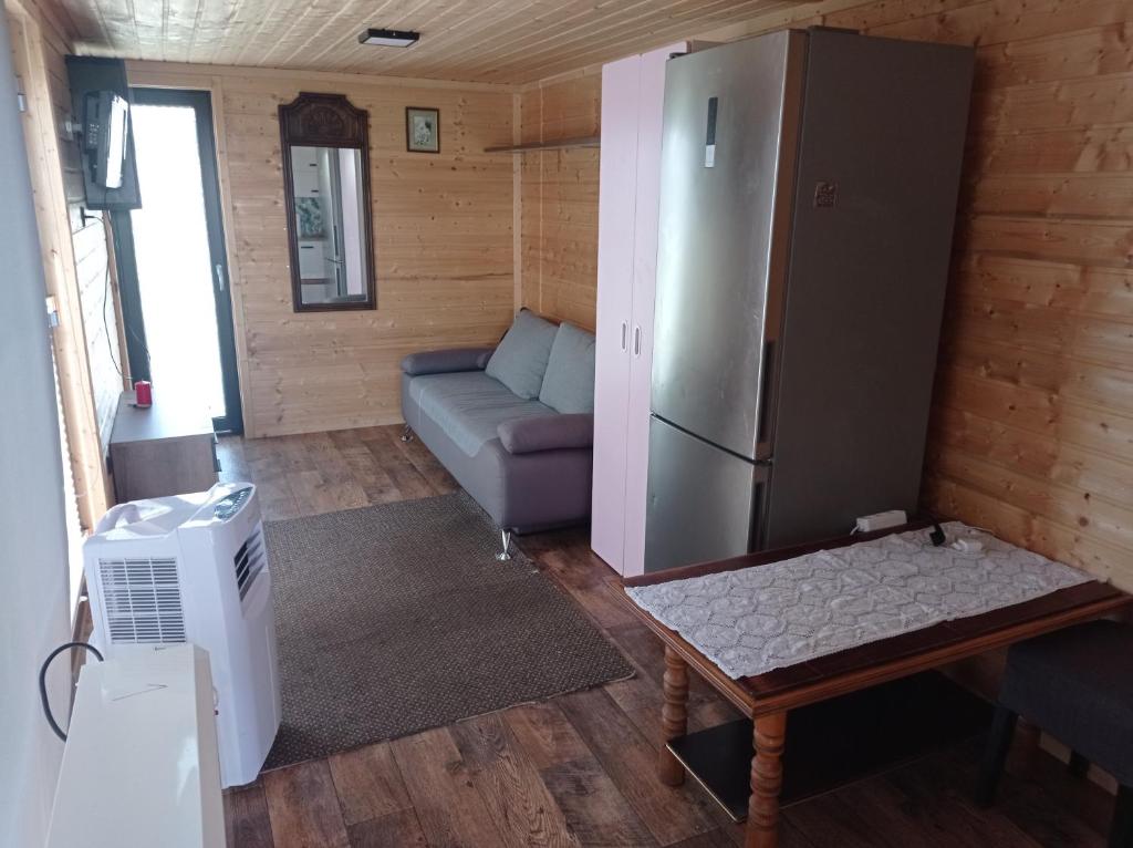 格但斯克Domek mobilny nad rzeką Gdańsk的客厅配有冰箱和沙发。