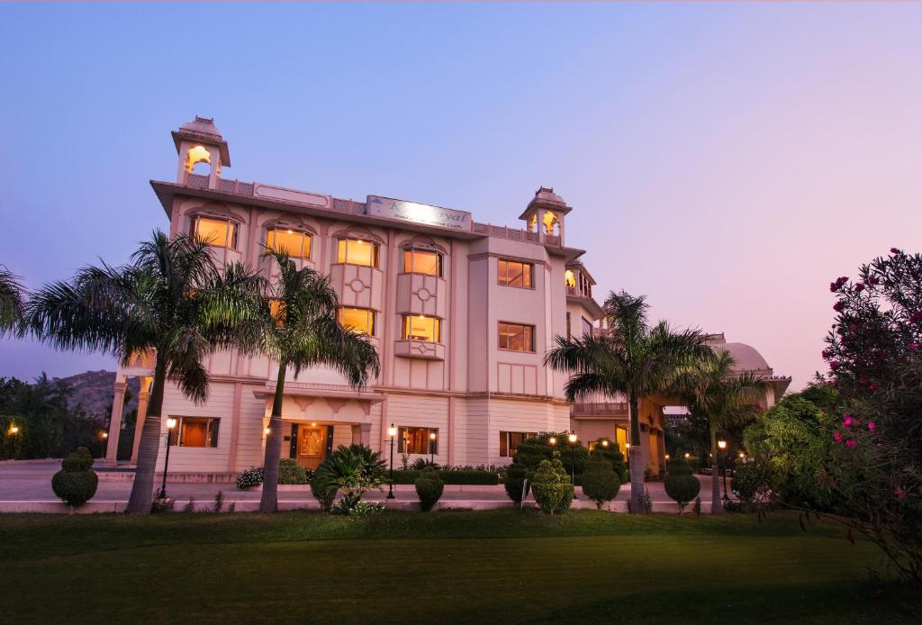 斋浦尔KK Royal Hotel & Convention Centre的一座棕榈树环绕的大建筑