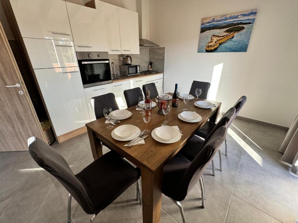 希贝尼克Apartman Mediteran的一张带黑色椅子的餐桌和一间厨房