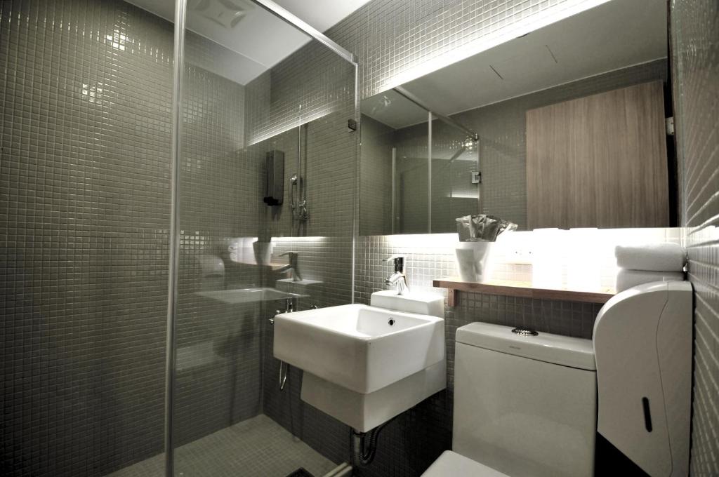 高雄河堤国际商旅的一间带水槽和玻璃淋浴的浴室