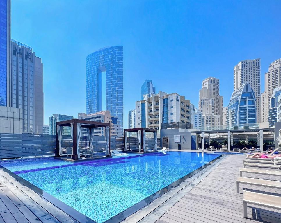 迪拜Exquisite 1 BDR apt in the heart of Dubai Marina- Studio One Tower的大楼屋顶上的大型游泳池