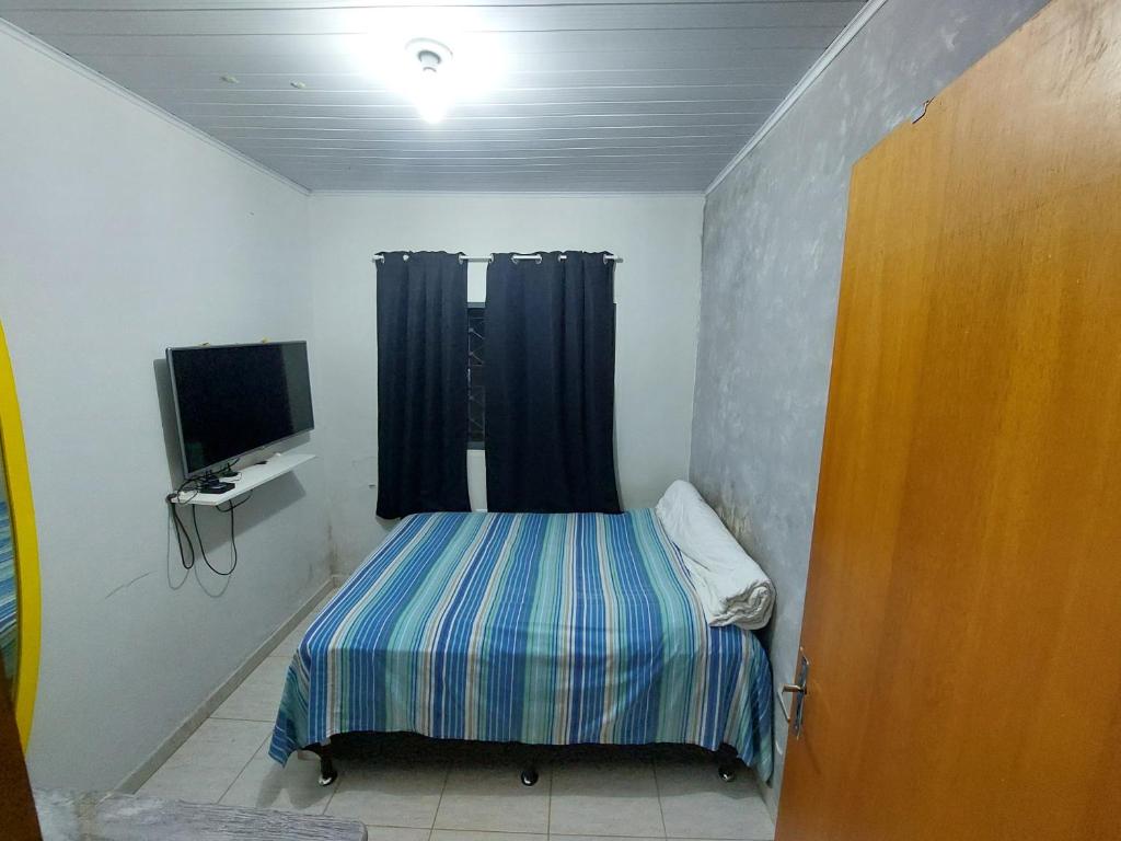 里贝朗普雷托Quarto para Agrishow的小房间设有床和电视