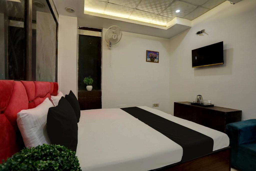 新德里OYO Kashish Residency的一间卧室配有一张床和一张红色的沙发