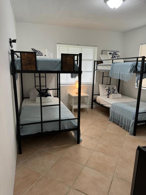 达尼亚滩Hostel Beds & Sheets FLL AIRPORT的一间房间,设有三张双层床