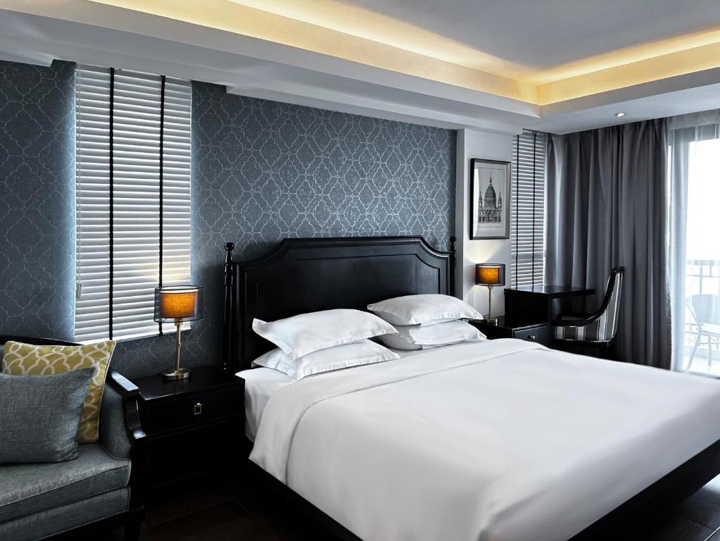 清迈Glory Boutique Suites 清迈古城荣耀精品酒店的卧室配有一张白色的大床和一张沙发。