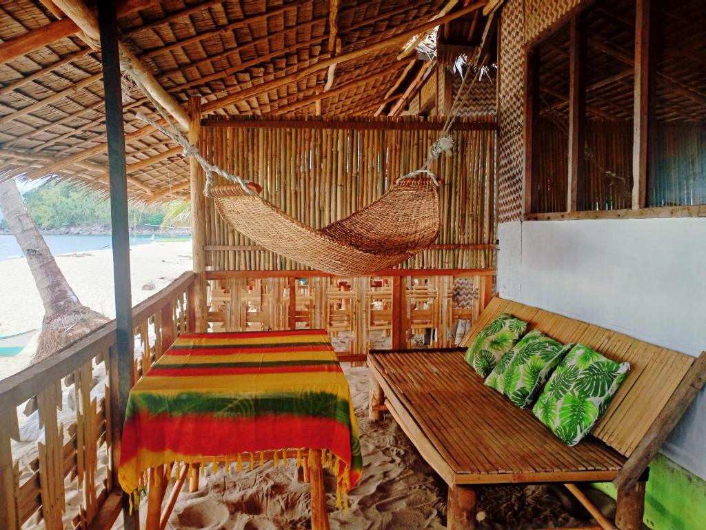 圣维森特Amwani Sunset Colours的小屋内的客房,配有吊床和长凳