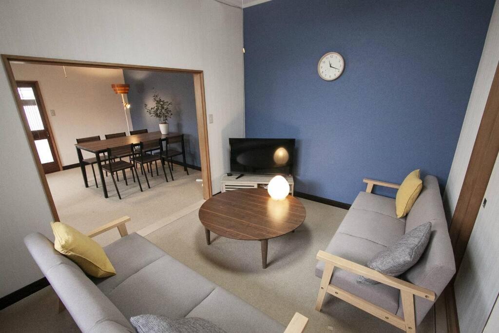 小樽Otaru Mickey House的带沙发、桌子和时钟的客厅