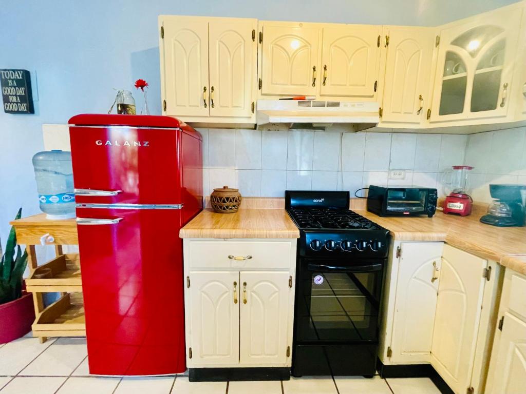 圣何塞德尔卡沃Casa Kante的白色橱柜厨房里的红色冰箱