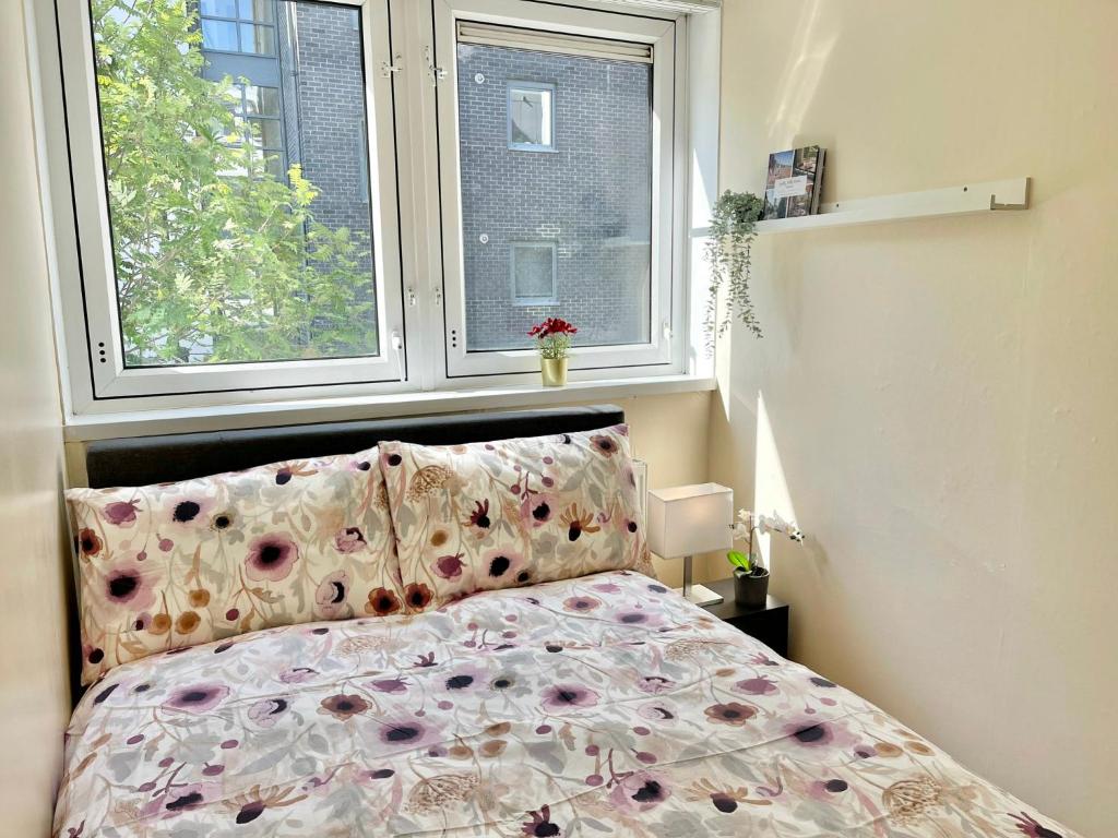 伦敦3BR flat in Central London close to Piccadily line的一间卧室配有一张带花卉床罩的床和窗户。