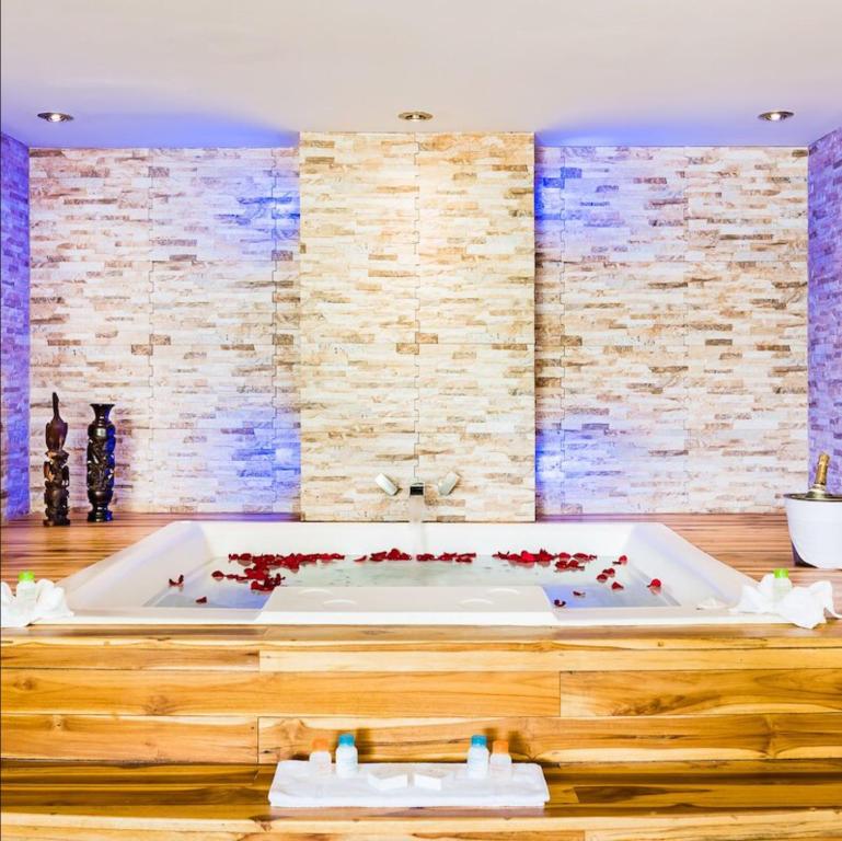 普拉亚弗拉明戈Margaritaville Beach Resort - Honeymoon suite - Costa Rica的浴室设有装有红色鲜花的浴缸。
