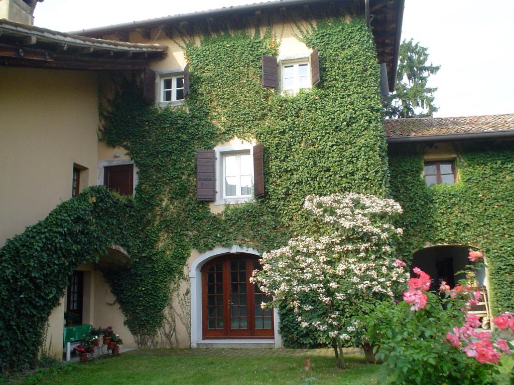 Trivignano Udinese卡萨安缇卡蒙莎依奇酒店的院子里的一座常春藤覆盖着鲜花的房子