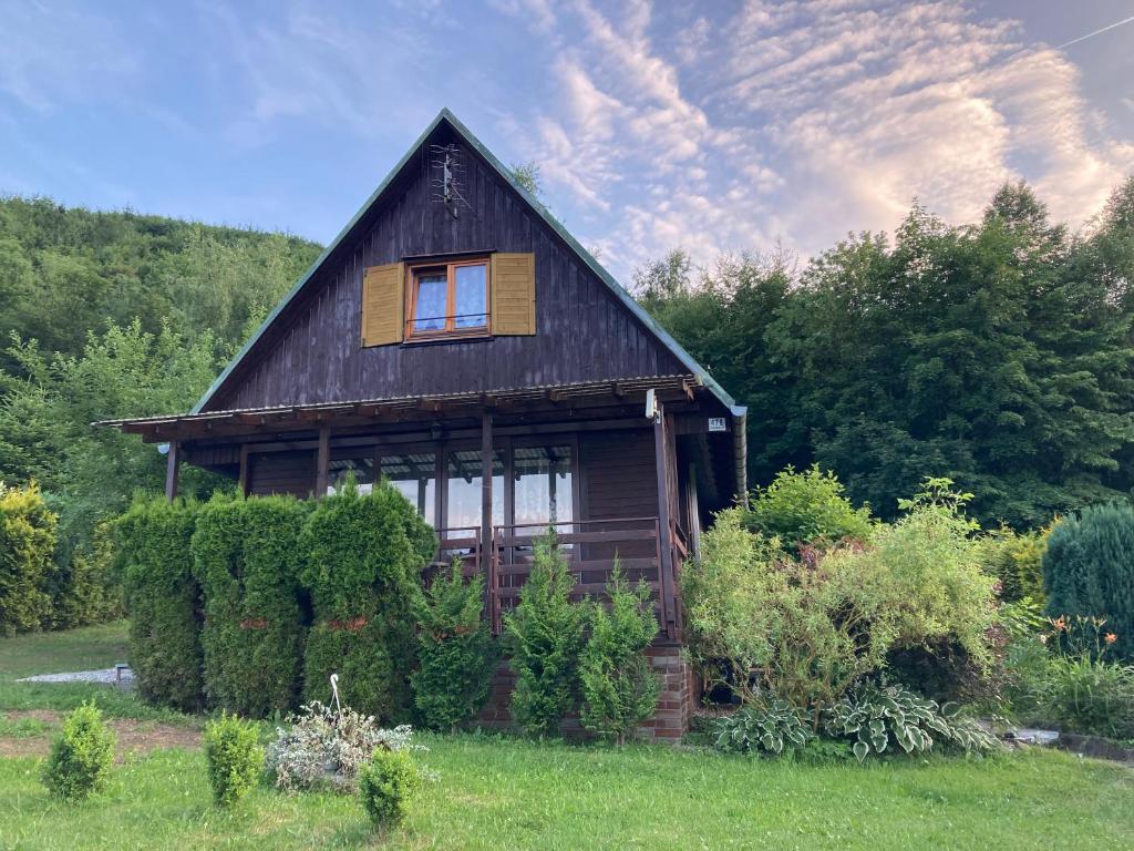 特罗亚诺维采Chata Koryška的田野上的窗户的小木房子