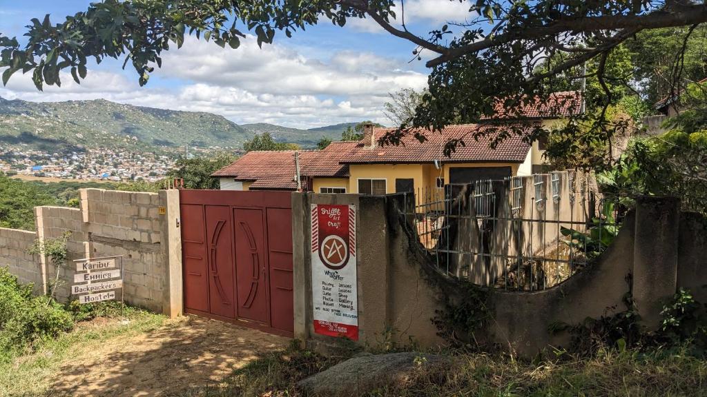 伊林加Safari Junction Backpackers hostel的一座有红色门和栅栏的房子