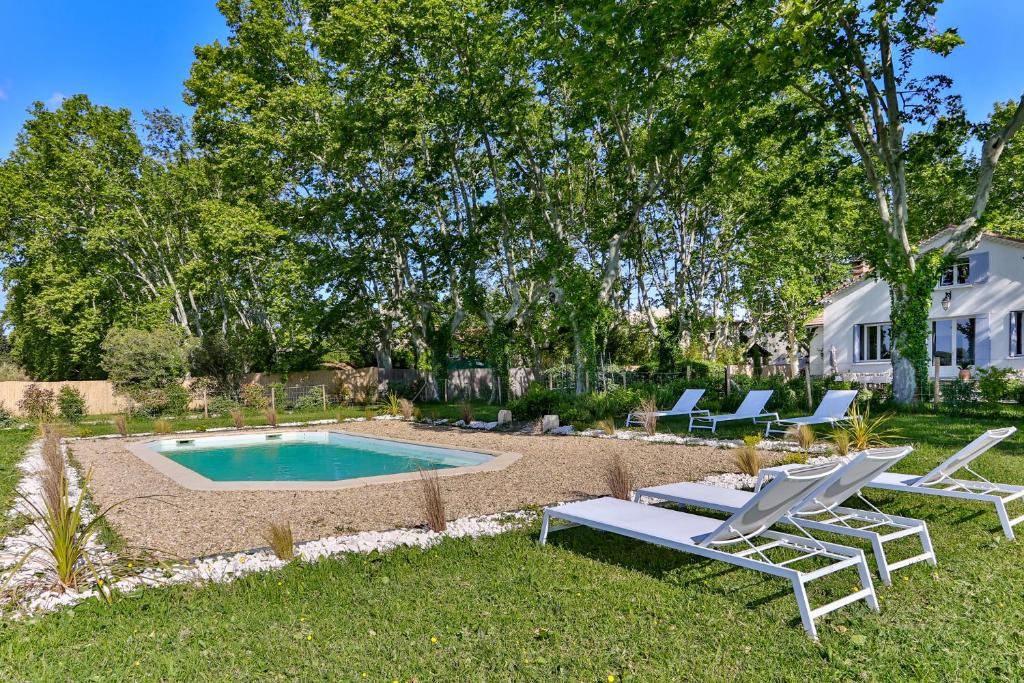 格拉沃松Villa Montel - Havre de paix à Graveson的后院设有游泳池、椅子和房屋