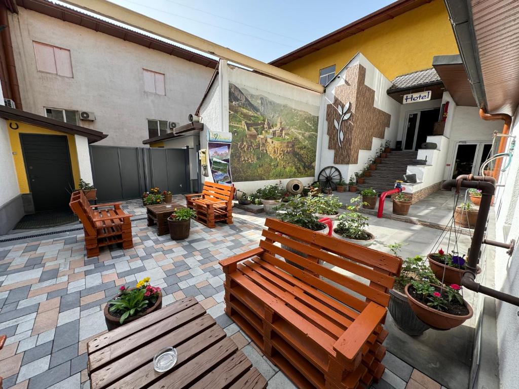 埃里温NO PROBLEM的庭院设有木凳和一些植物