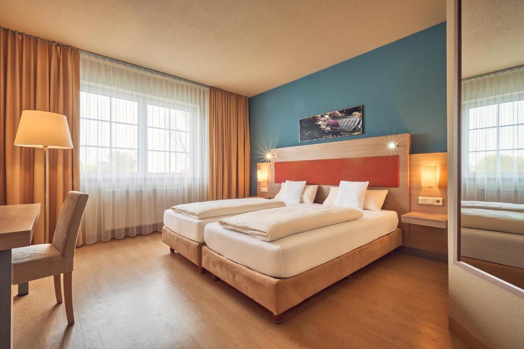 阿夫吉岑AKZENT Hotel Aufkirchen的酒店客房配有两张床和一张书桌