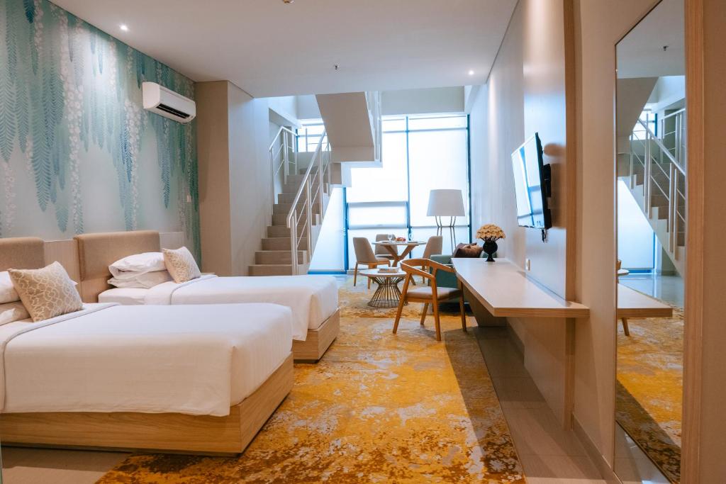 KedungbarukSkysuites Residence的酒店客房配有两张床和一张书桌
