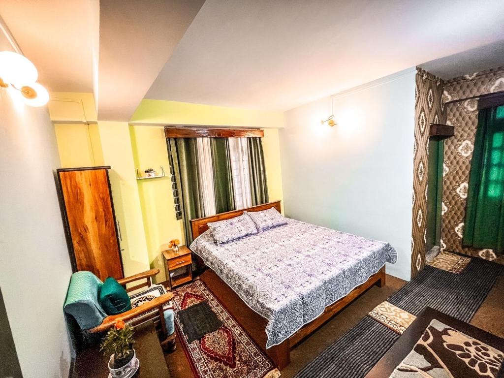 甘托克StayCation Homestay的一间小卧室,配有一张床和一把椅子