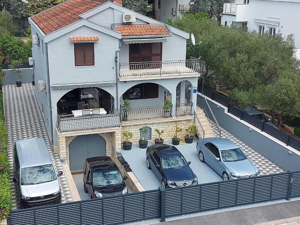 圣菲利普雅科夫Villa M & D的三辆车停在房子前面的停车场
