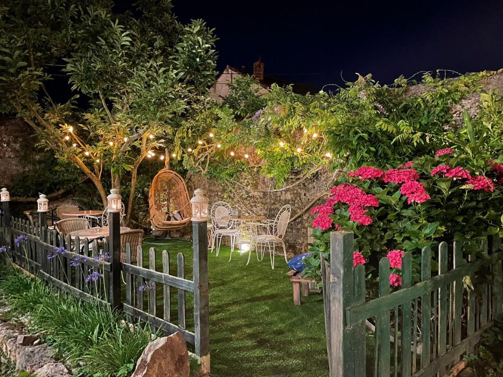 科伦加玛德尔苏夫酒店的花园内夜间带桌椅的围栏