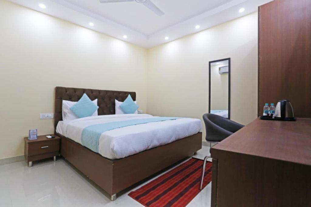 新德里Hotel Mannat at Paschim Vihar的酒店客房配有一张床、一张书桌和一张书桌。