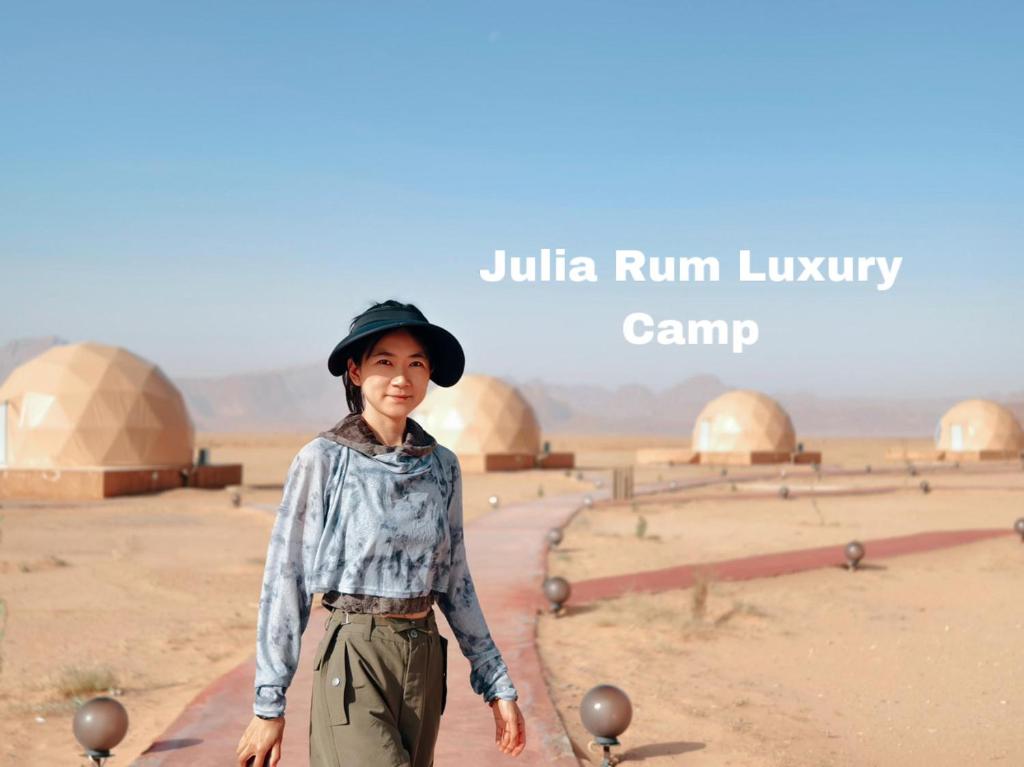瓦迪拉姆Julia Rum Luxury Camp的站在沙漠中的戴帽子的妇女