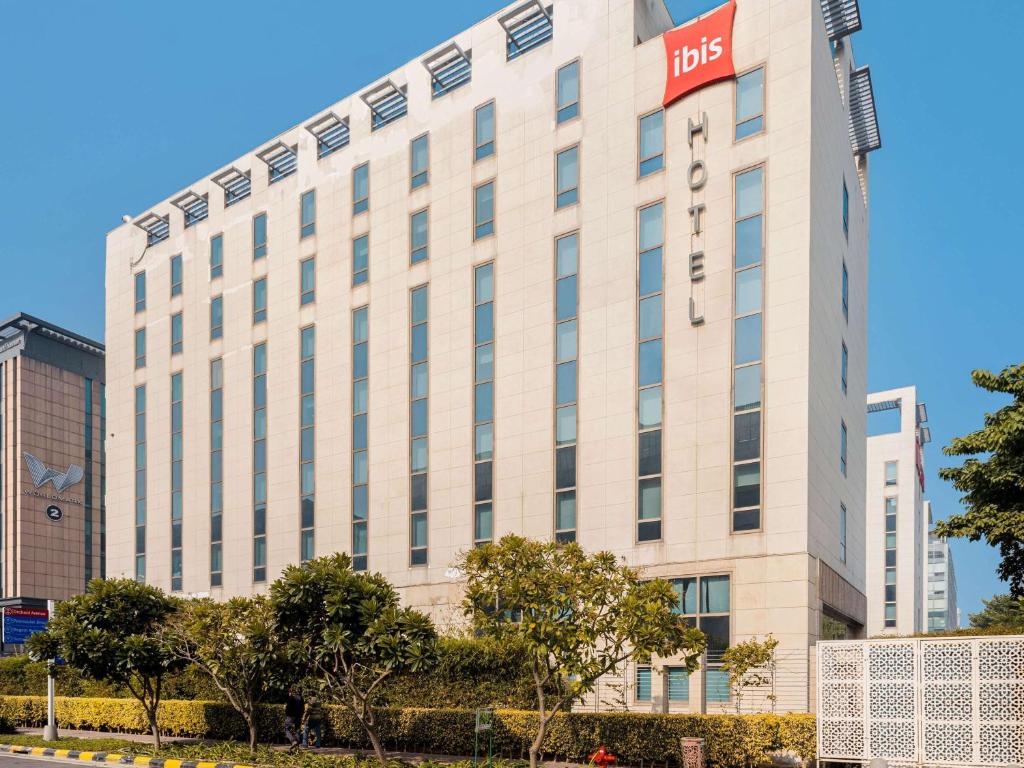 新德里ibis New Delhi Aerocity - An Accor Brand的白色的建筑,上面有一条带刺的标志