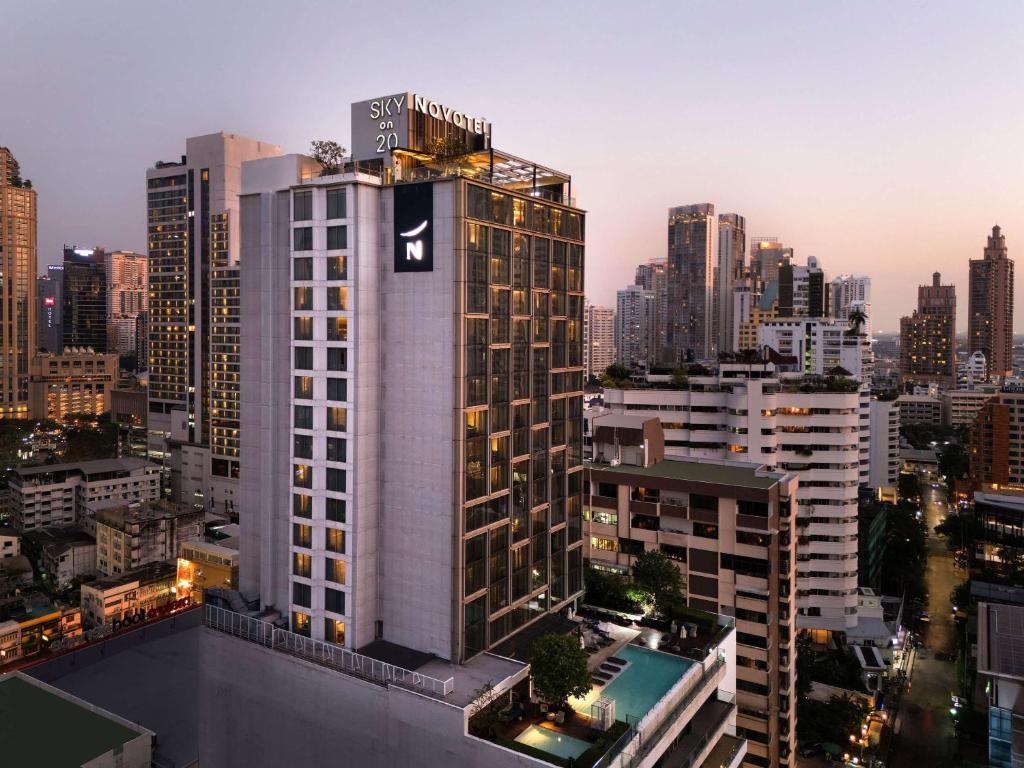 曼谷曼谷素坤逸 20 诺富特酒店的一座高大的建筑,上面有酒店标志