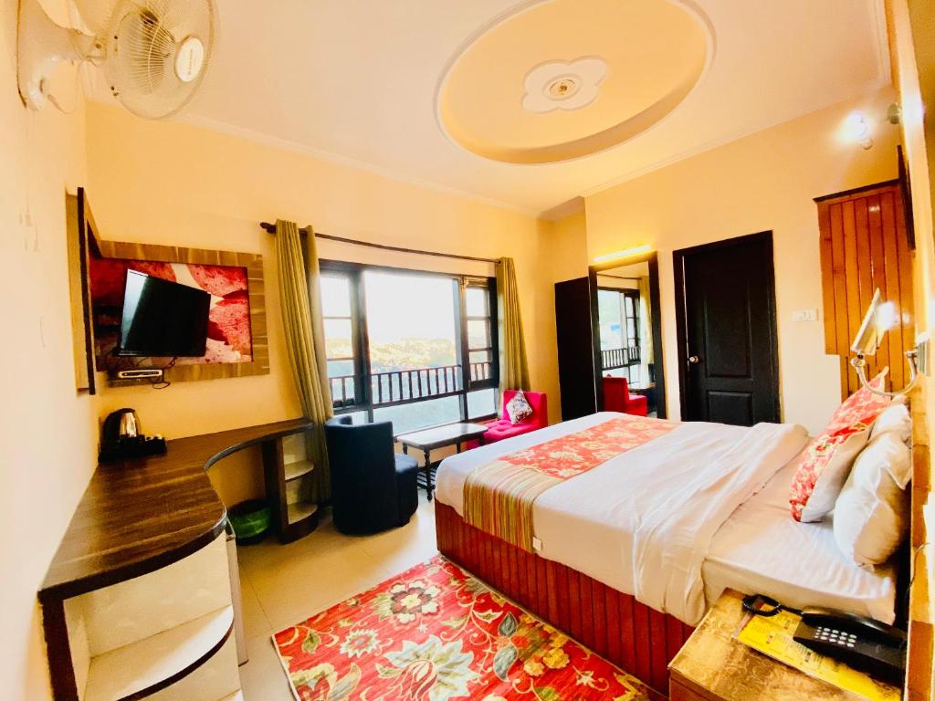 佩林Hotel De Regency的一间卧室配有一张床、一张书桌和一个窗户。