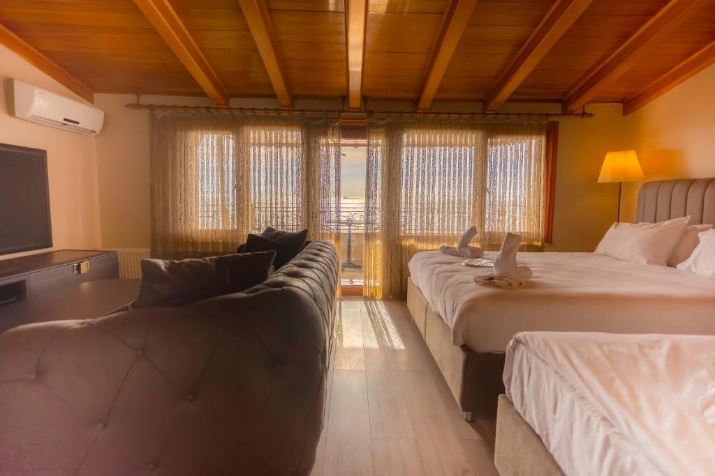 伊斯坦布尔欢呼灯塔酒店的酒店客房,设有两张床和一张沙发