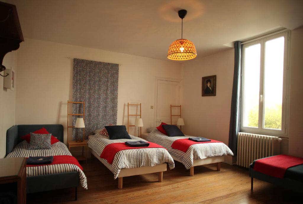 蒙特利马尔Maison Saint James的一间卧室配有两张床和吊灯。