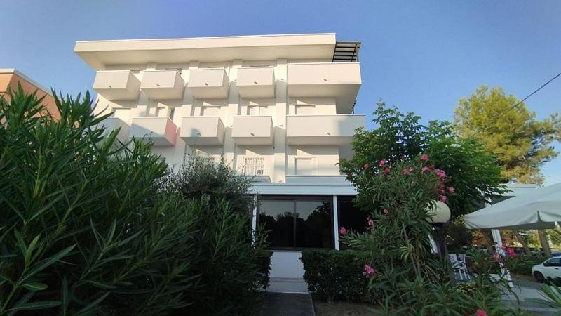 里乔内皮加勒酒店的一座白色的大建筑,前面有植物