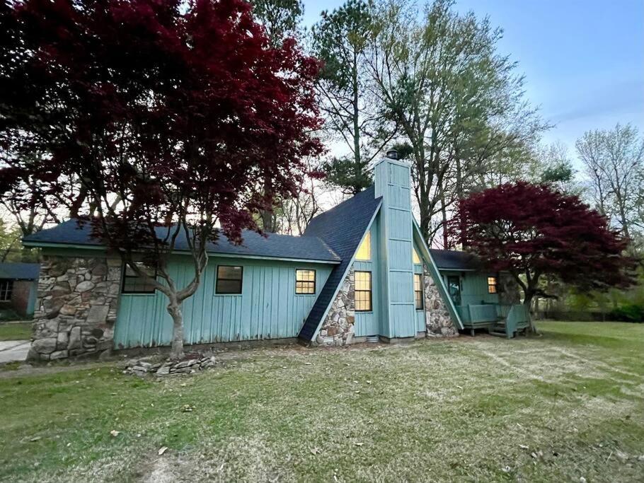Doc's Cottage - A-Frame in Piggott, AR的蓝色的石墙房子
