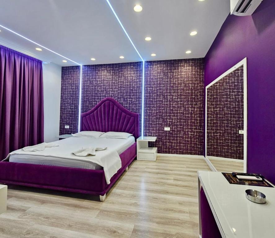 费里Hotel MoonLight的紫色卧室设有一张大床和紫色墙壁