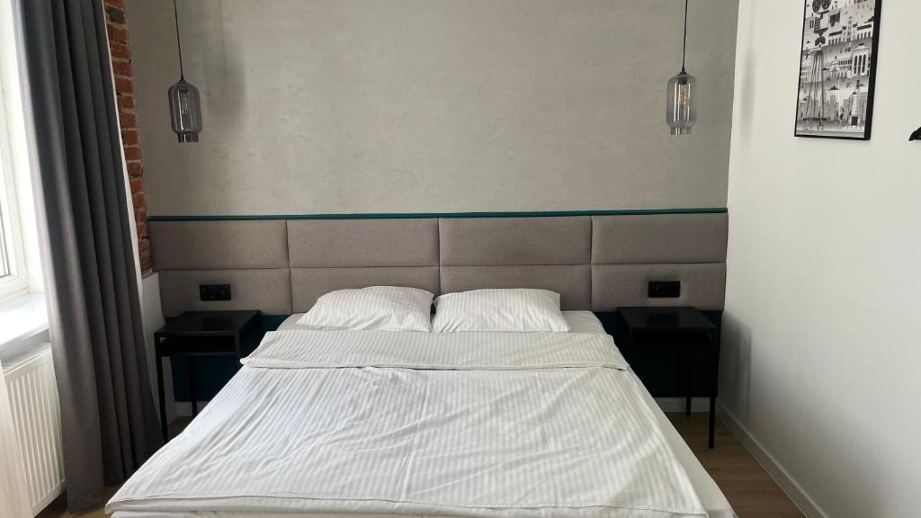 罗兹Kamienica Łódzka的一张位于房间的床,上面有两个枕头