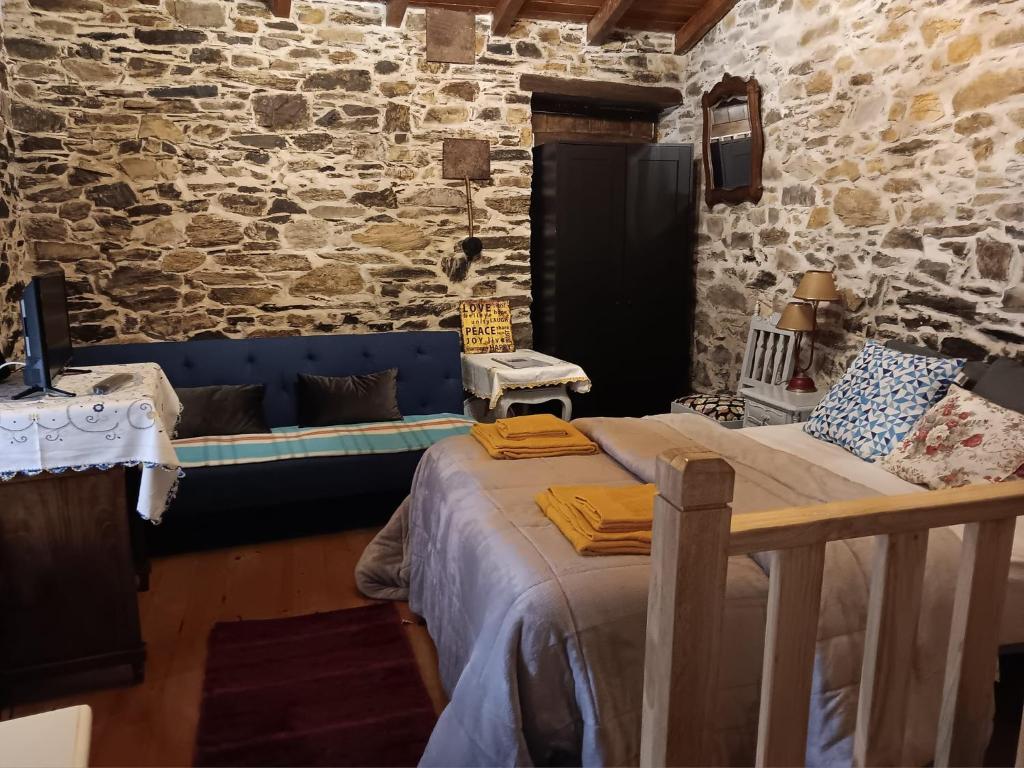 戈伊什Ceira Cottage的一间卧室配有一张床和一个沙发