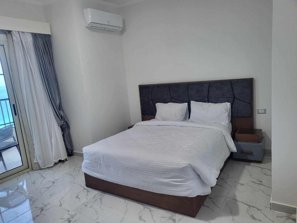 赫尔格达SAMA Beach Resort的一间卧室配有一张带白色床单的大床