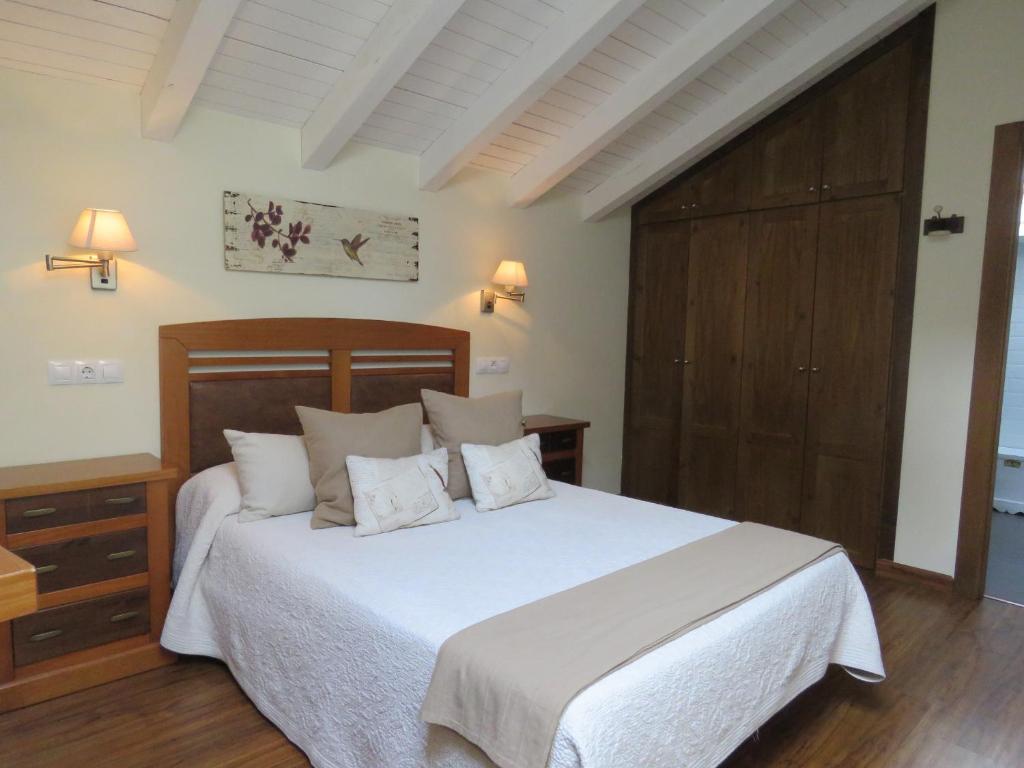 里瓦德塞利亚奥布德尔宾馆的卧室配有白色的床和木制床头板